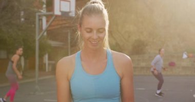 Kafkas bayan basketbolcunun portresi topu tutuyor ve kameraya bakıyor. Basketbol, şehir merkezinde spor eğitimi..