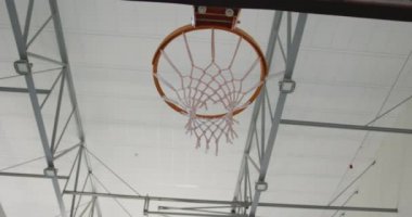 Afrika kökenli Amerikalı erkek basketbolcu maç sırasında gol atıyor. Basketbol, kapalı sahada spor eğitimi..