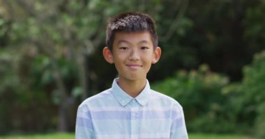 Bahçede gülümseyen ve gülen Asyalı mutlu çocuğun portresi. Karantina süresince evde tecrit altında..