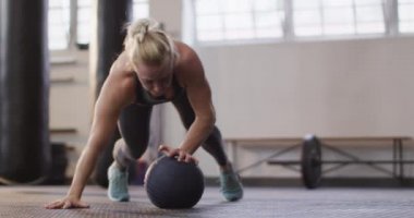 Spor salonunda tıp topuyla antrenman yapan beyaz bir kadın. Spor, antrenman ve spor konsepti