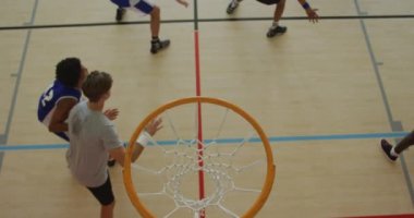 Afrika kökenli Amerikalı erkek basketbolcunun farklı oyunculara gol atması. Basketbol, kapalı sahada spor eğitimi..