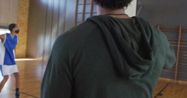 Çeşitli erkek basketbol takımları, ellerinde not panosu olan ve maske takan koçlarla maç yapıyor. Basketbol, kapalı bir sahada spor eğitimi Coronavirus covid 19 salgını sırasında.