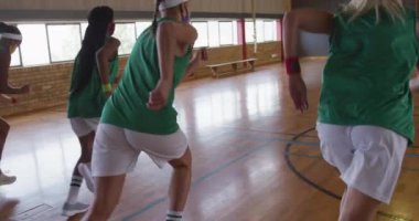 Çeşitli bayan basketbol takımları koşuyor, yüz maskeleri takıyorlar. Basketbol, kapalı bir sahada spor eğitimi Coronavirus covid 19 salgını sırasında.