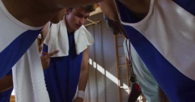 Çeşitli erkek basketbol takımı ve takım koçu oyun taktiklerini tartışıyorlar. Basketbol, kapalı sahada spor eğitimi..