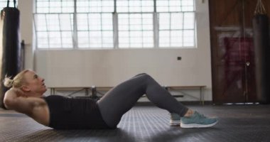 Beyaz kadın spor salonunda mekik çekerken yan görünüm. Spor, antrenman ve spor konsepti