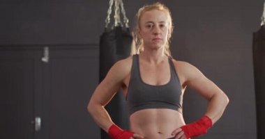 Kafkas kadın boksör portresi, elleri kalçasında spor salonunda duruyor. Spor, antrenman ve spor konsepti
