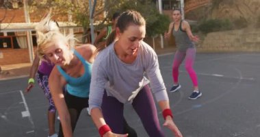 Çeşitli bayan basketbol takımları maç yapıyor, top sürüyor ve gol atıyor. Basketbol, şehir merkezinde spor eğitimi..