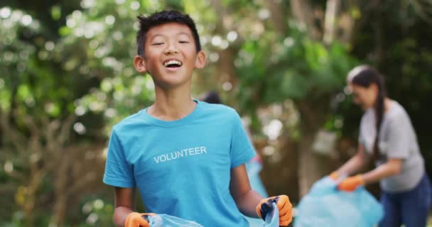 Сміється Азіатський Хлопчик Волонтерській Сорочці Яка Тримає Відмову Від Мішка — стокове відео