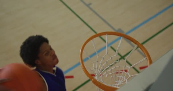 アフリカ系アメリカ人男性バスケットボール選手の得点目標の概要多様な選手に対して バスケットボール室内裁判所でのスポーツトレーニング — ストック動画