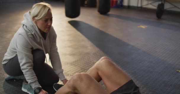 Kaukasiska Muskulös Man Tränar Gör Sit Ups Med Kvinnlig Tränare — Stockvideo