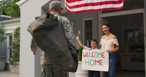 Счастливый Кавказский Солдат Приветствует Сына Жену Табличкой Добро Пожаловать Домой — стоковое видео