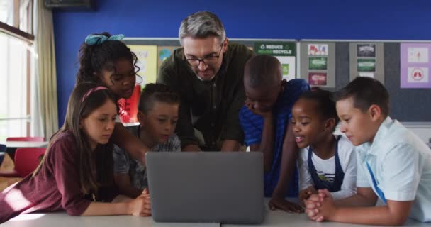 Diverso Maestro Masculino Grupo Escolares Mirando Computadora Portátil Niños Escuela — Vídeos de Stock