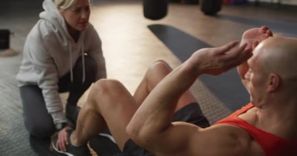Caucasian Muscular Man Exercising Doing Sit Ups Female Coach Health — Vídeos de Stock
