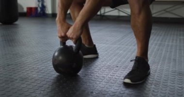 Spor salonunda kettle Bell 'le çalışan, fit, beyaz bir adamı yakından çek. Spor, antrenman ve spor konsepti