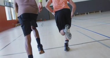 Çeşitli erkek basketbol takımları ve spor kıyafetleri giyen ve koşan koçlar. Basketbol, kapalı sahada spor eğitimi..