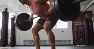 Beyaz erkek antrenör spor salonunda halterle çalışıyor. Spor. eğitim ve spor konsepti