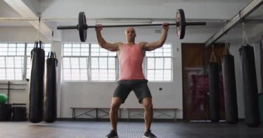 Beyaz erkek antrenör spor salonunda halterle çalışıyor. Spor. eğitim ve spor konsepti