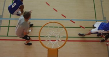 Afrika kökenli Amerikalı erkek basketbolcunun farklı oyunculara gol atması. Basketbol, kapalı sahada spor eğitimi..