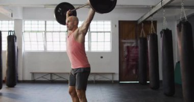 Beyaz erkek antrenör spor salonunda halterle çalışıyor. Spor. eğitim ve spor konsepti