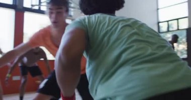 Çeşitli erkek basketbol takımları ve antrenörler maç yapıyor. Basketbol, kapalı sahada spor eğitimi..