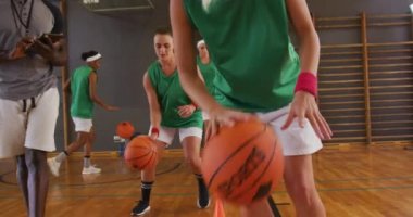 Çeşitli bayan basketbol takımları ve antrenman topları. Basketbol, kapalı sahada spor eğitimi..