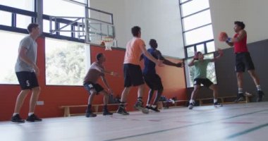 Çeşitli erkek basketbol takımları ve antrenörler maç yapıyor. Basketbol, kapalı sahada spor eğitimi..