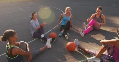 Spor giyimli, esneme hareketleri yapan çeşitli bayan basketbol takımları. Basketbol, şehir merkezinde spor eğitimi..