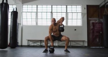 Kafkasyalı bir adam spor salonunda çaydanlık çanlarıyla çalışıyor. Spor, antrenman ve spor konsepti