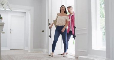 Evinde koşuşturan heyecanlı beyaz çocuk gülümseyen ailesini karşılamak için ön kapıdan giriyor. Mutlu aile, evde ev hayatı.