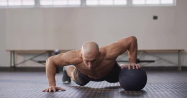 Spor salonunda beyaz bir adam tıp topuyla antrenman yapıyor. Spor, antrenman ve spor konsepti