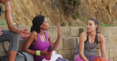 Çeşitli bayan basketbol takımları konuşuyor ve gülüyor. Basketbol, şehir merkezinde spor eğitimi..