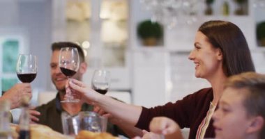 Gülümseyen beyaz anne aile yemeğinden önce kocası ve babasıyla kadeh kaldırıyor. çok nesildir birlikte evde vakit geçiriyoruz..