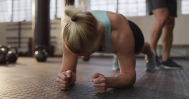 Spor salonunda kalas egzersizi yapan beyaz bir kadına yaklaş. Spor, antrenman ve spor konsepti