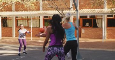 Çeşitli bayan basketbol takımları maç yapıyor, top sürüyor. Basketbol, şehir merkezinde spor eğitimi..