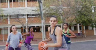 Çeşitli bayan basketbol takımları maç yapıyor, top sürüyor. Basketbol, şehir merkezinde spor eğitimi..