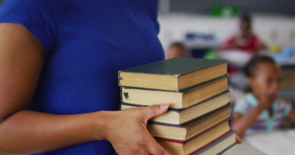 Portrait Happy Mixed Race Female Teacher Standing Classroom Books Children — Stock Video