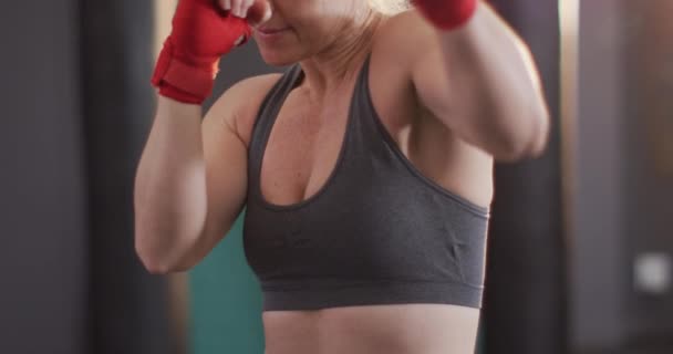 体操で彼女のパンチを練習する白人女性ボクサーのクローズアップ スポーツ トレーニング フィットネスの概念 — ストック動画