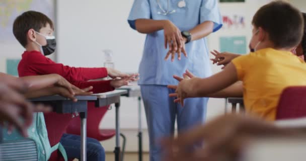 Diversi Scolari Operatori Medici Indossano Maschere Facciali Disinfettando Mani Classe — Video Stock