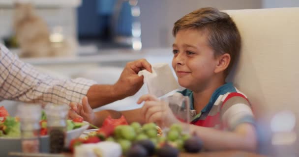 Masadaki Mutlu Beyaz Büyükbaba Aile Yemeği Sırasında Torununun Yüzünü Siliyor — Stok video