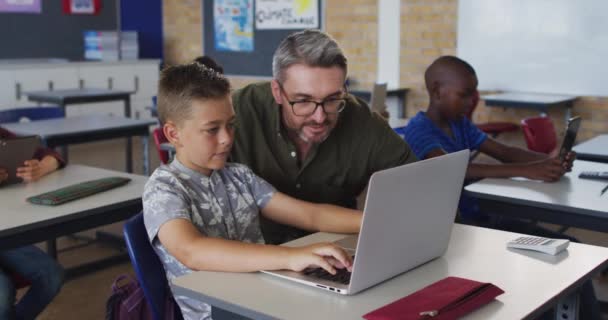 Mångsidig Manlig Lärare Hjälpa Skolpojke Sitter Klassrummet Med Bärbar Dator — Stockvideo