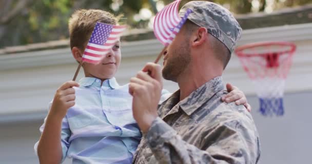 Feliz Soldado Caucásico Llevando Hijo Sonriente Sosteniendo Bandera Jardín Fuera — Vídeos de Stock