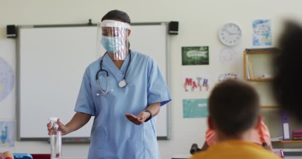 Blandet Race Kvindelige Læge Arbejder Iført Ansigtsmaske Viser Skolebørn Hvordan – Stock-video