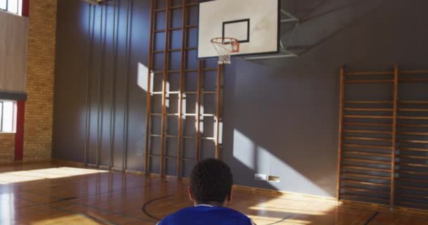 アフリカ系アメリカ人男性バスケットボール選手がボールでシュートを練習する バスケットボール室内裁判所でのスポーツトレーニング — ストック動画