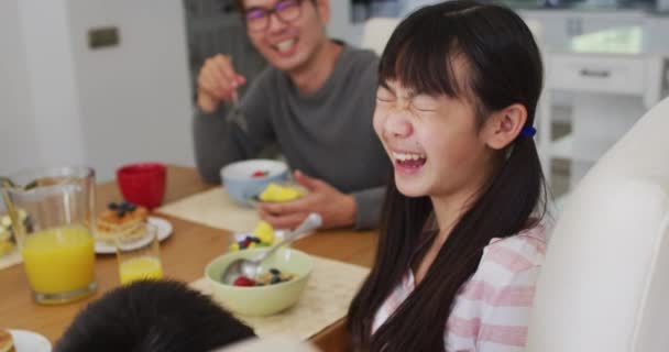笑う息子と娘と一緒に朝食を食べるキッチンで幸せなアジアの父 幸せな家族隔離された家で隔離された時 — ストック動画