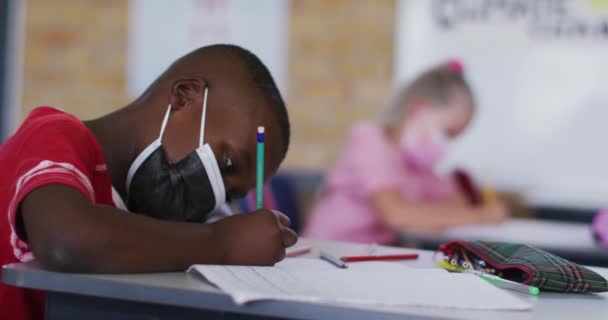 Portret Afrykańskiego Ucznia Siedzącego Klasie Robiącego Notatki Masce Dzieci Szkole — Wideo stockowe
