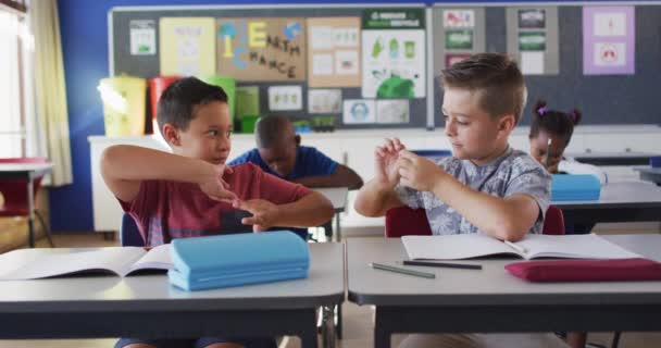 Zwei Unterschiedliche Schuljungen Lächeln Während Sie Klassenzimmer Sitzen Und Mit — Stockvideo