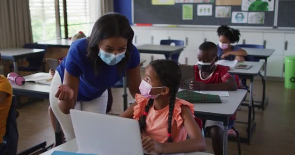 Professora Diversa Ajudando Colegial Usando Laptop Todos Vestindo Máscaras Faciais — Vídeo de Stock