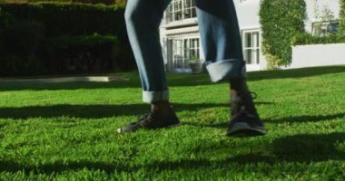 Afrika kökenli Amerikalı baba ve oğlu güneşli bir günde bahçede futbol oynuyorlar. Babalık ve aşk kavramı