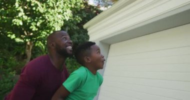 Afrikalı Amerikalı baba basketbol potasında smaç basmak için oğlunu taşıyor. Babalık ve aşk kavramı