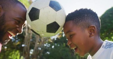 Afrikalı Amerikalı baba ve oğul bahçede başlarıyla futbol oynuyorlar. Babalık ve aşk kavramı
